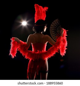 Burlesque Dancer With Red Plumage And Red Short Dress, Black And Red Background, On The Stage