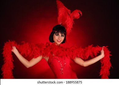 Burlesque dancer with red plumage and red short dress, black and red background