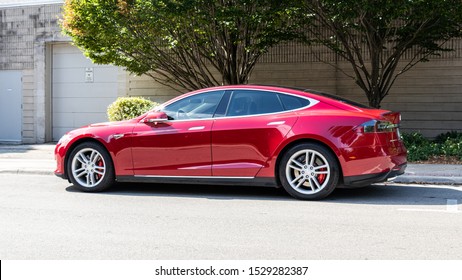 BURLINGTON, CANADA - September 30, 2019: Side-view of a red Tesla Model S parked on the side of a road on a sunny day.