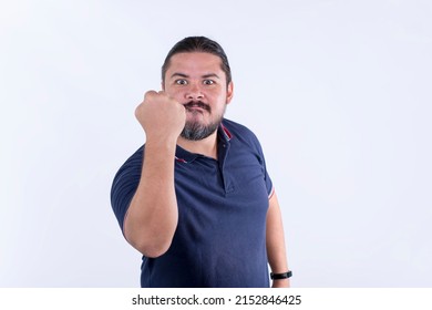 A burly and stocky man warns someone with his fist to keep their distance or not to piss him off. Livid and offended.