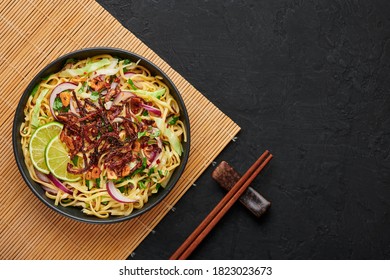 Burmese Atho in black bowl on dark slate table top. Atho is myanmar indian cuisine dish popular in Chennai. Asian food and meal. Top view. Copy space - Shutterstock ID 1823023673