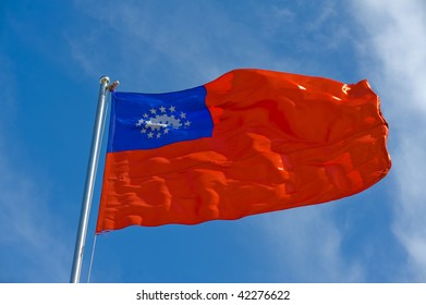 Burmese Flag On A Pole Against Blue Sky