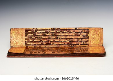 Burmese Manuscript (KAMMAVACA) lacquered palm leaves with large tamarind script written in black resin on red and gold background