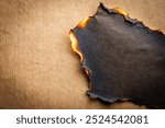 Burn black paper with fire damaged on beige background for your presentation