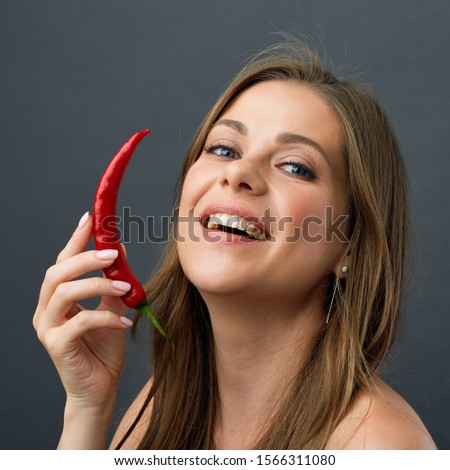 Burn you fat with hard dieting. Close up portrait of woman holding red chilli pepper.
