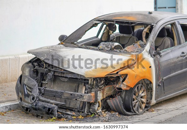 Burned car, burned-out car body. Road\
wreck accident or arson fire burnt wheel car vehicle junk          \
                                                  \
