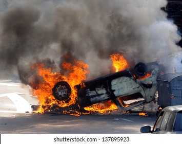 Burned car during street riots - Shutterstock ID 137895923