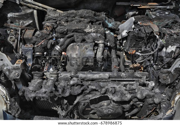 Burned and\
damaged car engine after fire\
accident