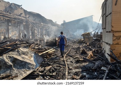 Burned And Damaged Industrial Complex. Firefighter Inside Burned Factory. Remnants Of Burnt Down Building. Fire Damage. Damaged Industrial Halls.