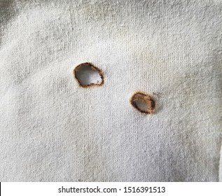 Burned holes on old white cotton cloth