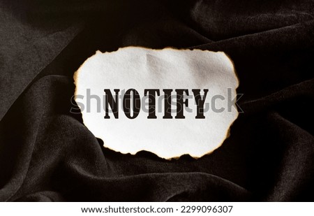 Burned paper on a black background with text NOTIFY