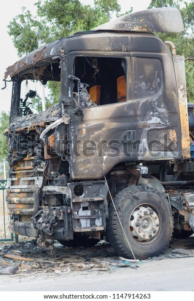 Burned truck in a roadside\
with a burnt-out driver\'s\
cab,  accident.  
