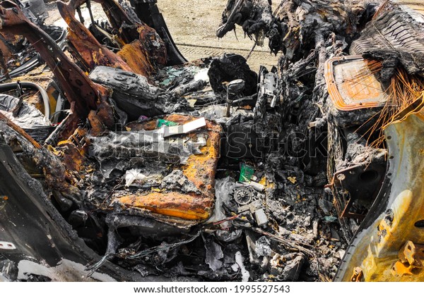 Burned-out car after arson accident. Melted plastic\
in a fire.