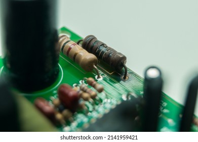 A burned-out resistor on an electronic circuit board. A high-temperature damaged part of an electronic device. Electronics repair. Selective focus
