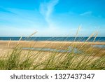 Burnham Overy Staithe beach in Norfolk with grasses in foreground