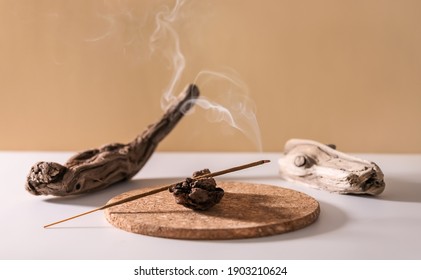 Burning aromatic incense stick for yoga meditation and relaxing on wooden minimalistic background. Aromatherapy smoke.
