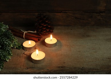 burning aromatic scented tealight candle glass on wooden table with background of vintage wooden wall of cottage in living room to create relax ambient vibes of Christmas party celebration new year	 - Powered by Shutterstock