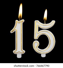 Burning birthday candles on black background, number 15