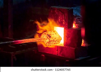 Burning  in a blacksmith forge.  Making metal items in smithy. In the smithy a red-hot iron piece in a hot fire flame is ready for further processing