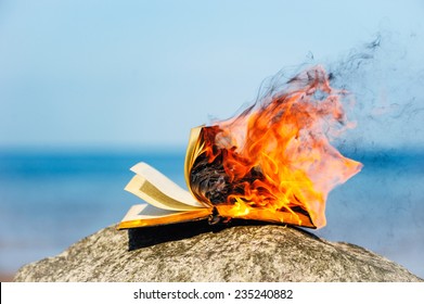 Burning book on the sea coast