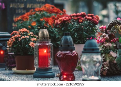 burning candle and chrysanthemum flower decoration on grave in the cemetery - Shutterstock ID 2210592929