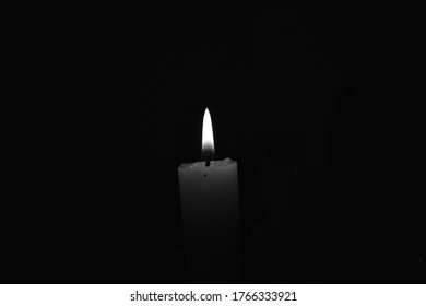 Burning candle in a dark place - Shutterstock ID 1766333921
