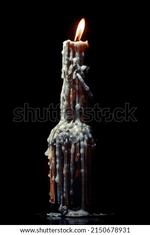 Burning Candle with melting wax in glass bottle