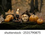 burning candle, moon amulet and decorative pumpkins in forest, autumn nature background. Samhain, Halloween. Witchcraft, esoteric spiritual ceremony. magic ritual. witch aesthetic. autumnal equinox