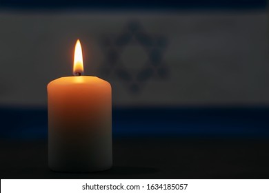Burning candle on the background of the flag of Israel. Memorial Day