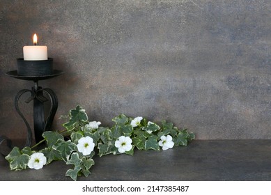 Burning Candle With Petunias And Ivy. Motive For Card Mourning, Death, Condolence Or Religious Ceremony.