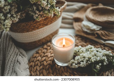 Burning candle in spring interior.