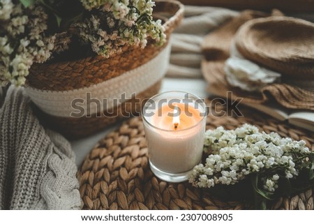 Burning candle in spring interior.