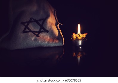 burning candle and the Star of David against a black background, We will never forget, the Jewish Holocaust and Heroism Remembrance Day