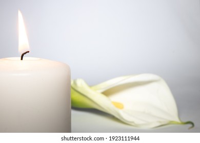 Burning Candle And White Calla Lily On White Background With Copy Space. Sympathy Card