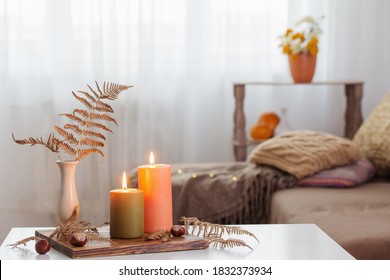 Burning Candles With Autumn Decor On White Table At Home