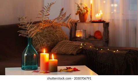 Burning Candles With Autumn Decor On White Table At Home