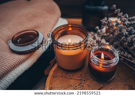 Burning candles, book and lavender, aesthetic autumn photo.
