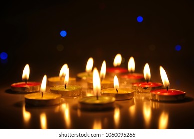 Burning candles in the dark on the table, warm toning