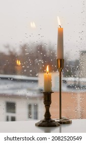 Burning Candles On Background Rainy Window Pane