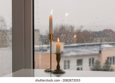 Burning Candles On Background Rainy Window Pane