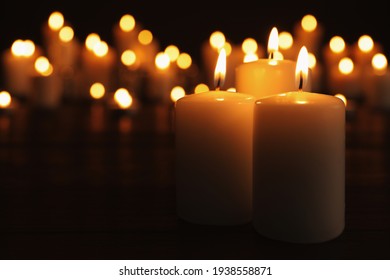 Burning candles on dark table, space for text. Memory day