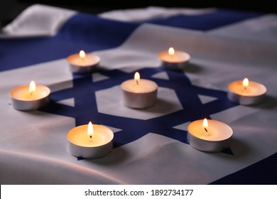 Burning candles on flag of Israel. Holocaust memory day