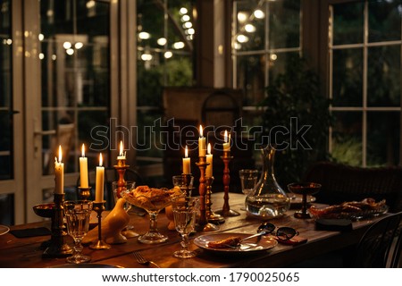 Burning candles on the table in a cozy house in the evening decorate the table with food. Evening romantic dinner at the restaurant.