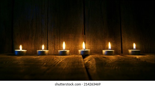 Burning candles. On a wooden background.