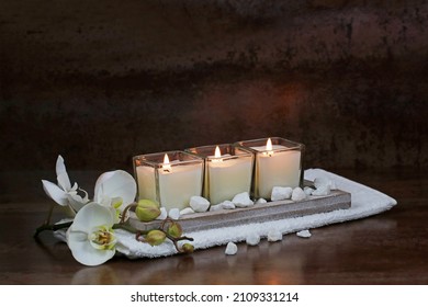 Burning candles with orchid flowers