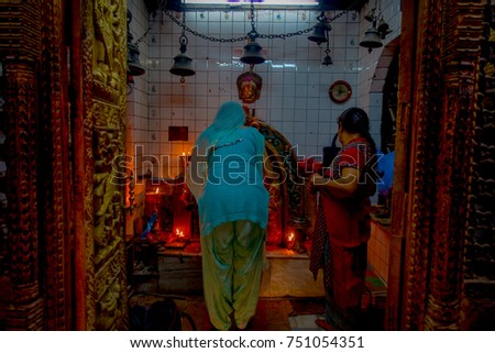 Burning candles in a row, darkness inside temple. Kathmandu, Nepal, Asia