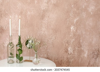 Burning candles, vase with flowers and mirror on table near color wall - Shutterstock ID 2037474545