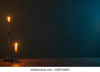 burning candles in vintage candlesticks on dark background - Shutterstock ID 2209756891