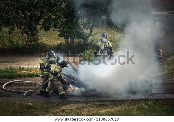 Burning car. Fire extinguish a burning passenger\
car, which exudes  white smoke.\
Russia, Republic of Tatarstan,\
July 15, 2018.