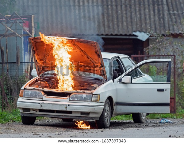 Burning car Fire suddenly started\
engulfing all the car. Man extinguishes car engulfed by\
fire.